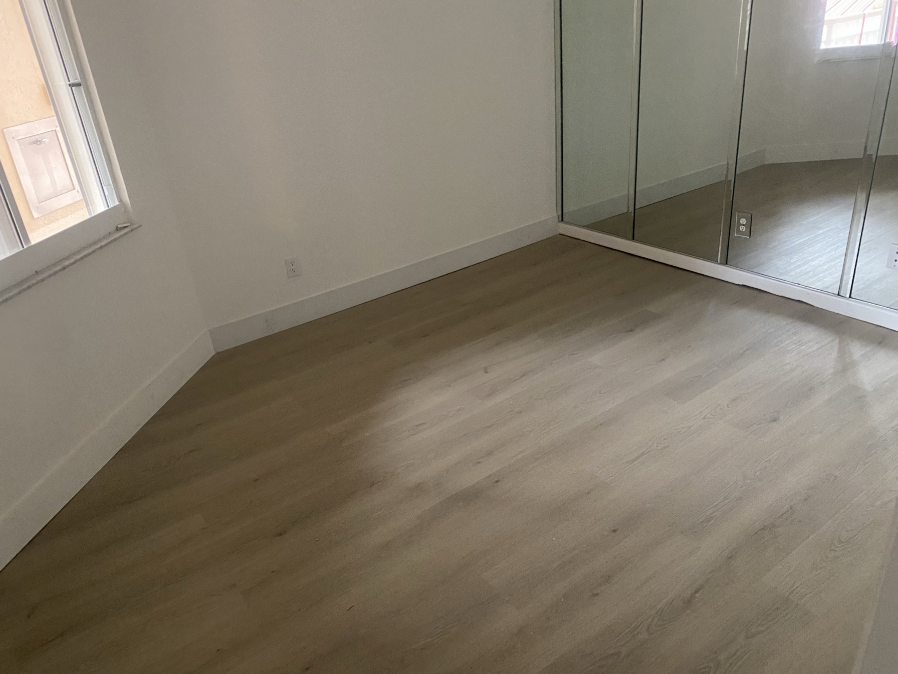 Same condo bedroom with repaired walls, fresh paint, and new flooring